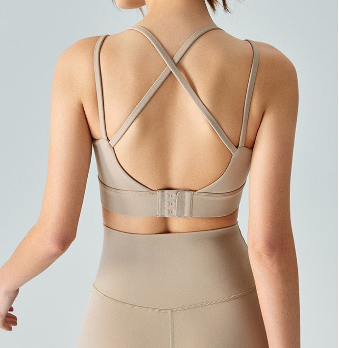 Back shot of woman wearing brown ucharm sports bra with built-in bra for yoga.