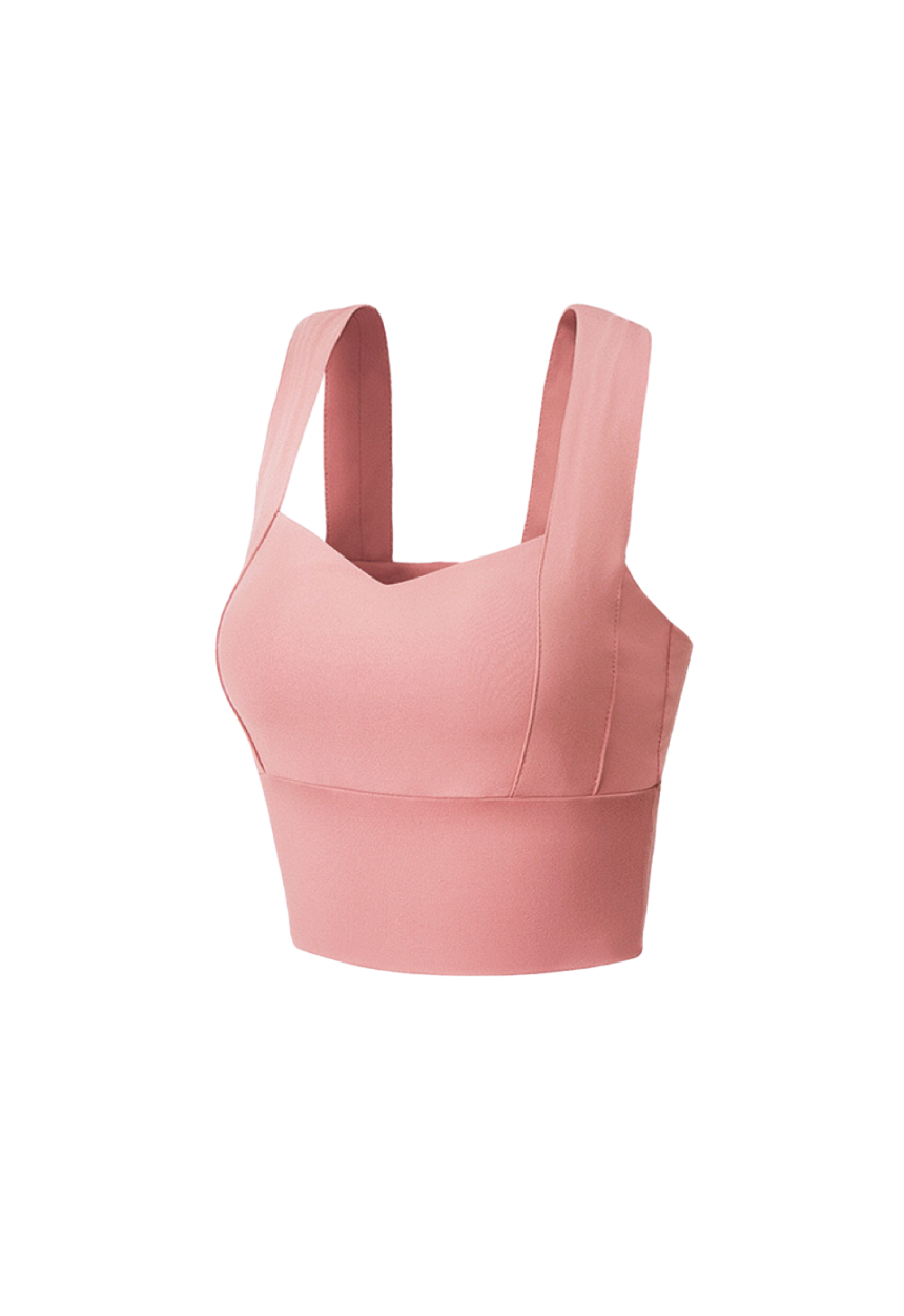 "Confident plus-size woman posing in a rose-pink supportive sports bra"