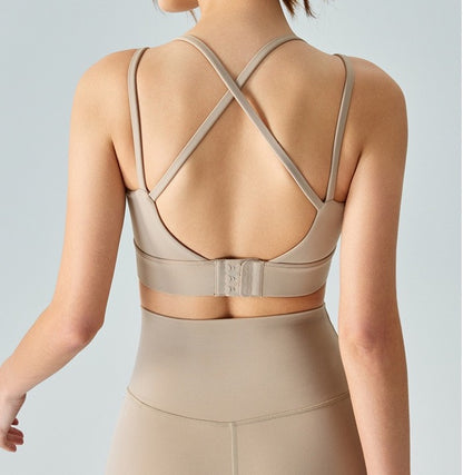  Back shot of woman wearing brown ucharm sports bra with built-in bra for yoga.