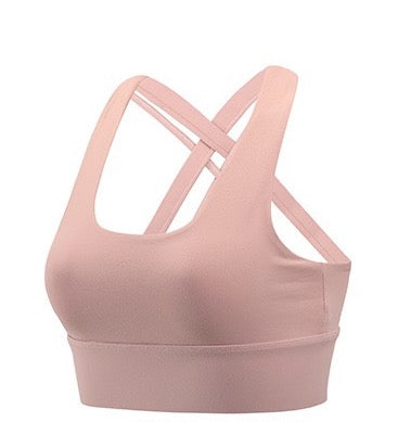 A pink sports bra top for women with a cross-over design, u neck, removable padding, ideal for yoga.