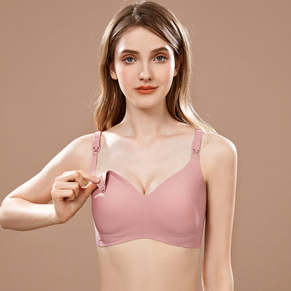 Model demonstrating the practicality of a soft-pink nursing bra with jelly strip support and single-hand unbutton feature.