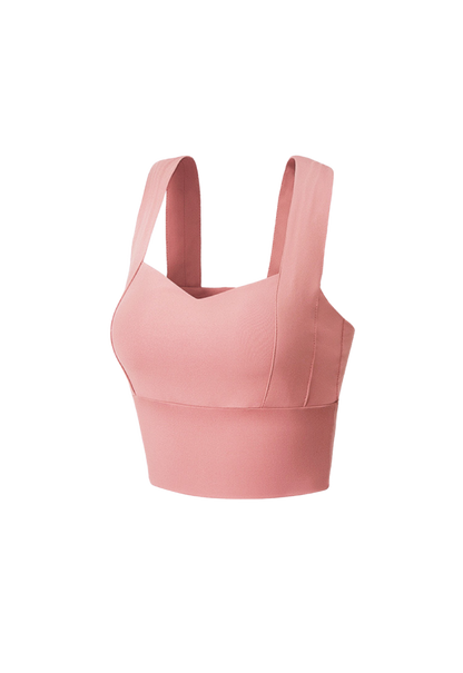 "Confident plus-size woman posing in a rose-pink supportive sports bra"