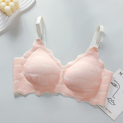 "Pale pink maternity bra with seamless design and quick-release clasps for nursing"