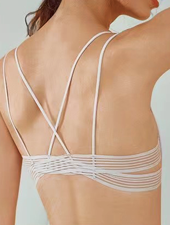 "Rear view of a woman wearing a light gray ultra-thin bra showing the strappy back design"