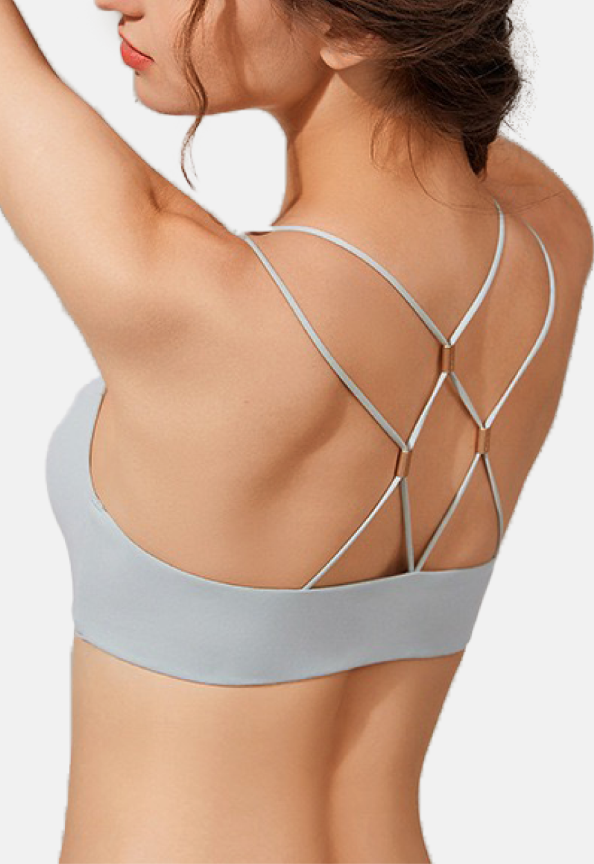 "Back view of a woman showcasing the intricate strap detailing on a light blue seamless bra"