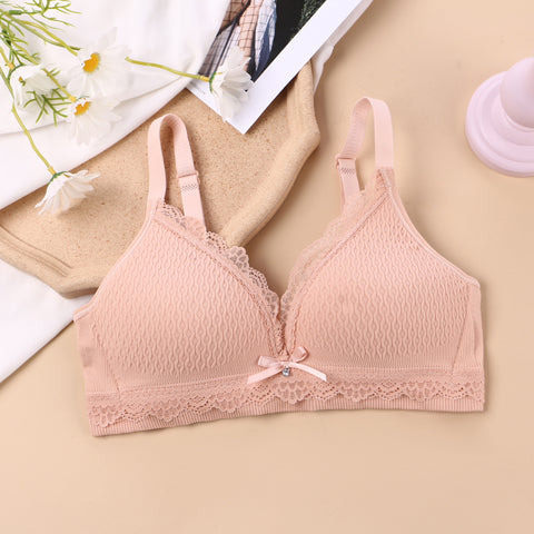 Soft blush pink wireless bralette with intricate lace knitting, designed for seamless comfort and a flattering back strap detail, perfect for a no-show look under clothing.